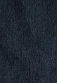 Tela de mezclilla oscura con un sutil tejido de sarga, que muestra una textura suave y un color azul profundo consistente, con ligeras variaciones en el sombreado.