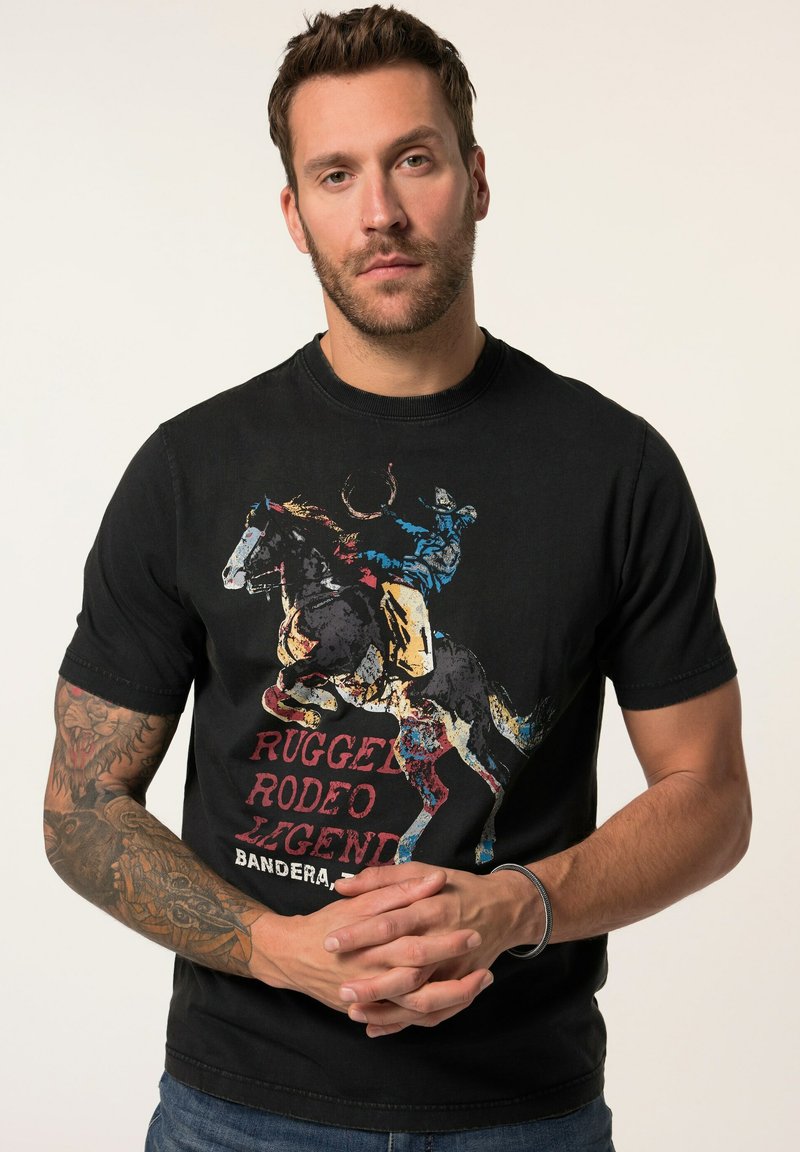 Schwarzes Baumwoll-T-Shirt mit einem bunten Grafikmotiv eines Cowboys auf einem Pferd, mit dem Schriftzug "RUGGED RODEO LEGENDS" in fettem Rot und Gelb.