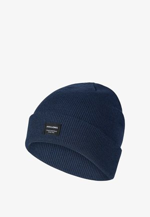 Marineblaue gestrickte Mütze mit geripptem Muster und umgeschlagenem Bündchen. Verfügt über ein kleines schwarzes Etikett mit weißem Text.