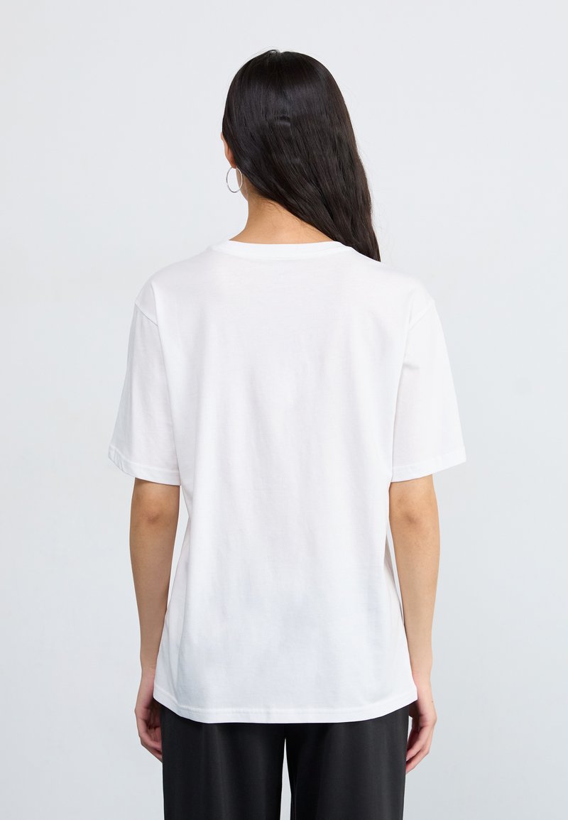 Camiseta de algodón blanca con un ajuste relajado, mangas cortas y un escote redondo. Textura suave sin patrones o acentos visibles.