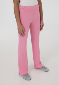 Pantaloni a campana rosa realizzati in tessuto liscio, con vita alta, cuciture laterali e un bottone decorativo dorato in vita.