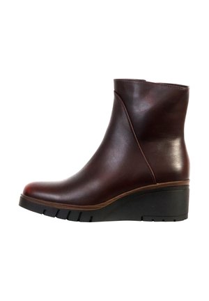 Stivaletto in pelle marrone scuro con tacco a zeppa e suola nera scanalata, design elegante, vista laterale su sfondo bianco.