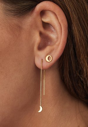 Boucles d'oreilles en or avec un clou circulaire et une chaîne suspendue, ornées d'une lune croissante et d'un pendentif en barre droite. Fini métallique lisse.