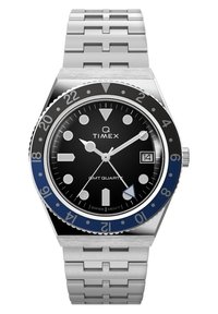 Montre à quartz Timex Q GMT avec bracelet en acier inoxydable, cadran noir, lunette bleu et noir, index lumineux et affichage de la date.