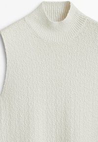 Pull sans manches couleur crème avec un col roulé haut côtelé. Tissu en maille texturée présentant un motif subtil et irrégulier.