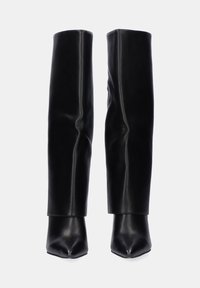 Botas negras hasta la rodilla en suave cuero sintético con punta afilada y diseño ajustado. Sin hardware visible ni patrones.
