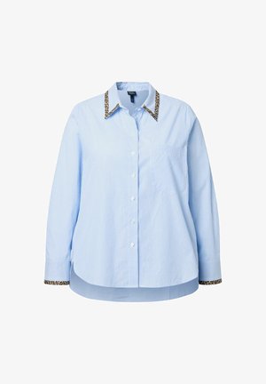 Camisa de botones azul claro con rayas verticales, que presenta un cuello y puños con estampado de leopardo. Hecha de una tela suave, con un corte oversized.