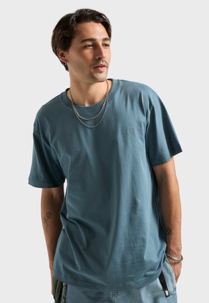 Blauw T-shirt met korte mouwen van zacht katoen met een ronde hals, voorzien van een klein borduursel op de borst en een comfortabele pasvorm.