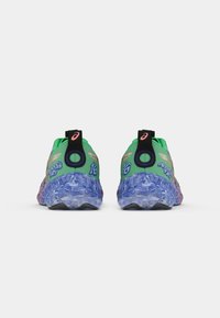 Zapatillas deportivas verdes con una suela azul translúcida y texturizada. Presentan acentos coloridos y una marca en la parte trasera y los laterales.