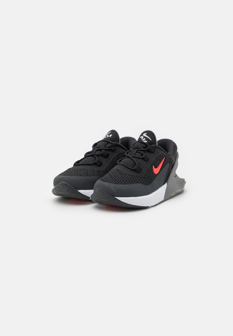 Scarpe sportive nere con tomaia in rete traspirante, accento di logo rosso, suola ammortizzata e un dettaglio di design bianco sul lato.
