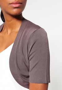 Kort mouw, open cardigan in een effen donker taupe stof met een gladde textuur, met een minimalistisch ontwerp en subtiele stikdetails.
