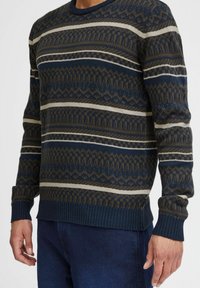 Kootud sviiter, millel on geomeetriline muster tumesinisel, beežil ja pruunil taustal. Riba äär ja hem, ümmargune kaelus ning tekstuuriga detailid kogu ulatuses.