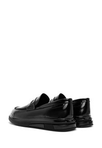 Zwarte loafers met een glanzende afwerking, ronde neus, gestikte accenten en een gevoerde zool. Instapmodel met twee decoratieve banden bovenop.