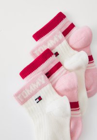 Tre par med sokker i rosa og hvit. To har ribbede kanter med "TOMMY"-logo; en har fargede striper og logo-detalj på ankelen.