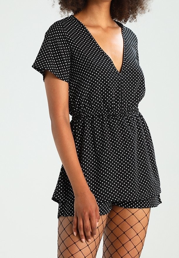 Mustapilkkuinen rompershorts, jossa on lyhyet hihat, V-pääntie ja joustava vyötärö. Yhdistetty verkkosukkiin. Pehmeä, kevyt kangas.