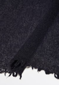 Mørkt, tekstureret stof med en løs, frynset kant, der har en let skinnende overflade og et vævet udseende i nuancer af dyb marineblå.
