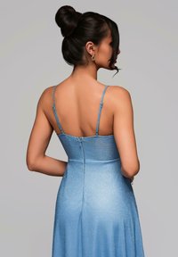 Blå ärmlös klänning med en åtsittande liv och utsvängd kjol, med en subtil glittrig textur och en dragkedjeslutning baktill.