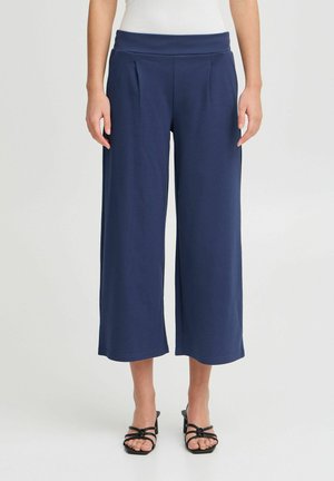 Marineblauwe wijde broek met een rekkende tailleband en plooien, gemaakt van zachte stof, met een gladde textuur en een enkellange snit.
