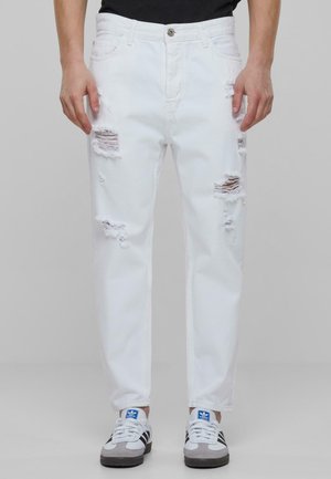 Valged denimsäärised, millel on mitmed kulumiskohad, klassikaline viie taskuga disain ning sirge lõige, koos nööbiga.