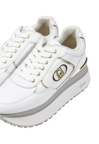 Sneakers platform bianchi con accenti dorati, tomaia in pelle testurizzata, punta rotonda e suola in gomma bianca con dettagli del logo e lacci.