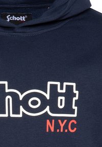 Felpa in blu navy con un grande logo bianco "Schott" e "N.Y.C" in rosso. Realizzata in tessuto testurizzato con design con cappuccio.