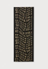 Cachecol preto com texto repetido em dourado, exibindo palavras como "COUTURE" e "JEAN". Textura suave, forma retangular, design moderno.