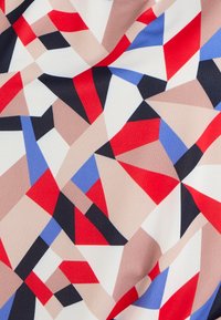 Geometrisch bedrukte stof met rode, blauwe, beige en zwarte vormen op een witte achtergrond, met een gladde textuur en een zachte val.