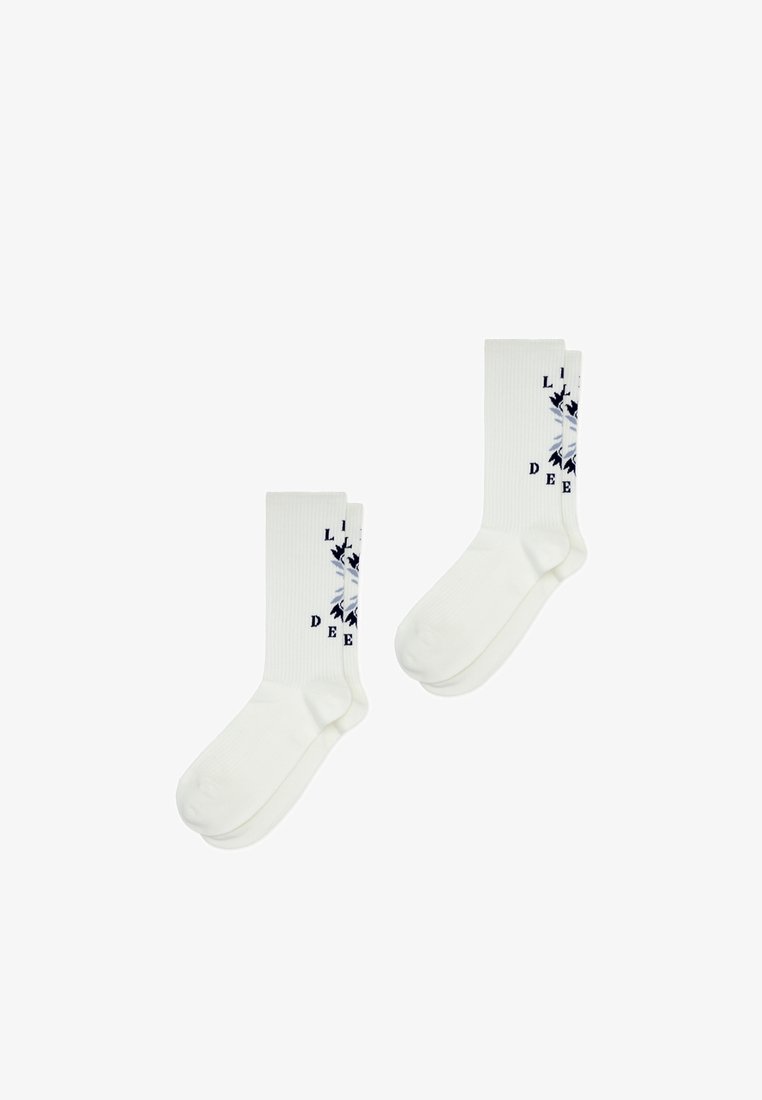 Chaussettes blanches en coton avec une texture côtelée, un motif graphique bleu portant le texte "LIFE DEEP", et des zones renforcées au niveau des orteils et des talons.
