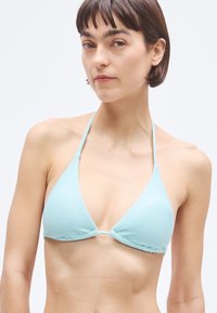 hele sinine triibuline bikiinitop, millel on kolmnurkne disain, õhukesed nöörkinnitused ja tekstureeritud pind. Ilma metall detailide või kaunistusteta.