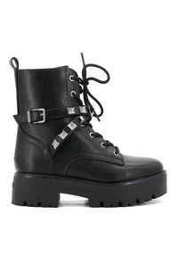 Botín de cuero negro hasta el tobillo con diseño de cordones, suela plana tipo plataforma, detalle de correa con tachuelas plateadas y ojetes prominentes.