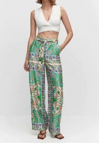 Pantalon Palazzo vert avec motifs paisley et floraux ; tissu léger, coupe ample, taille à cordon, poches latérales, ourlet plat.