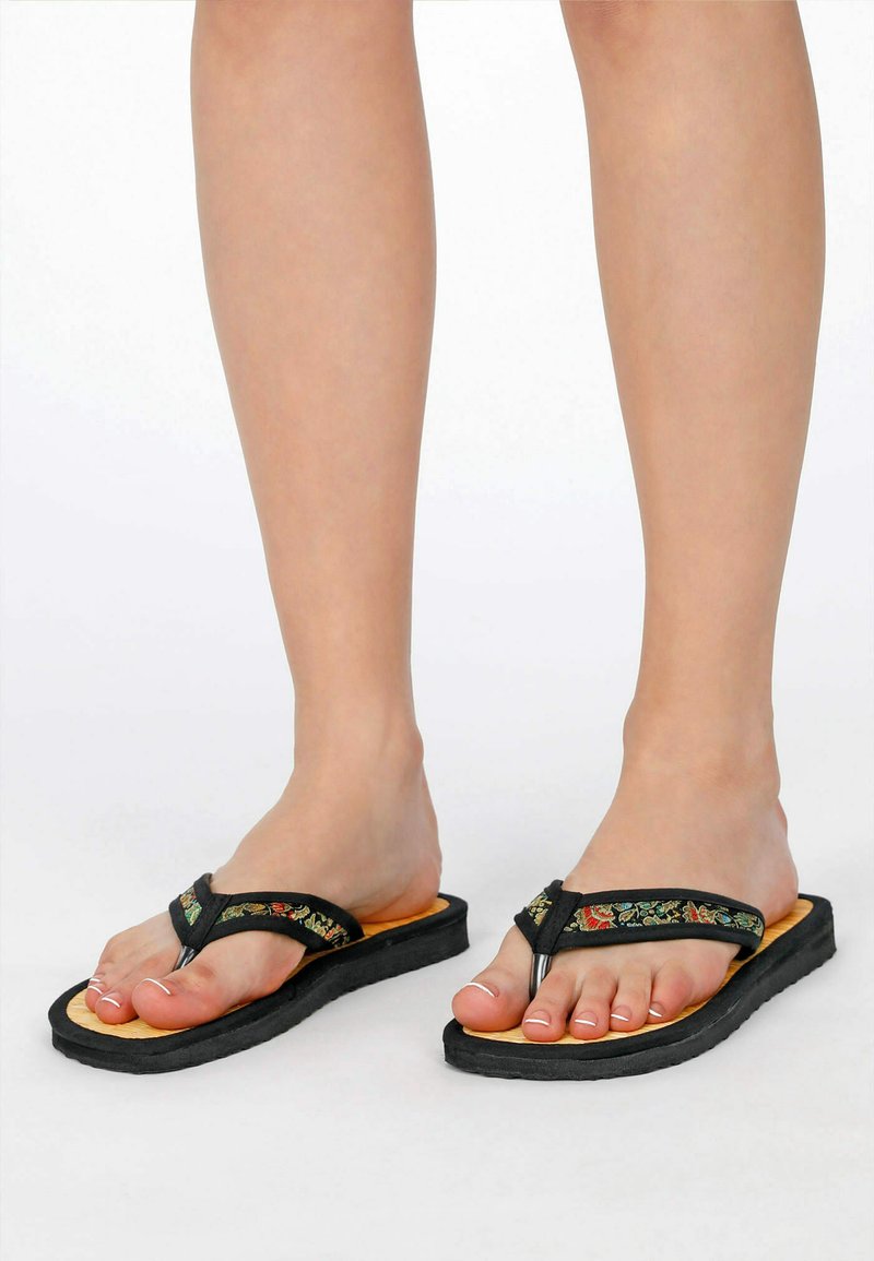 Black flip-flops with embroidered straps, featuring a textured black sole and a brown footbed, designed for comfort and casual wear.