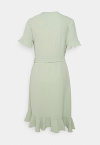 Robe vert clair avec des manches courtes à volants, une taille ceinturée et un ourlet évasé. Texture lisse avec un design simple et fluide.