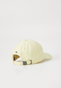 Casquette de baseball en coton jaune avec une visière incurvée, une sangle ajustable et un logo brodé à l'arrière. L'intérieur présente un motif rayé.