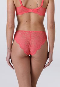 Set di reggiseno e slip in pizzo corallo con motivi floreali trasparenti, bordi a scallop, spalline regolabili e chiusura con gancio sul retro.