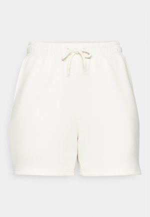 Kremfargede shorts laget av myk stoff, med elastisk midje og snor, og en avslappet passform. Ingen synlige lommer.