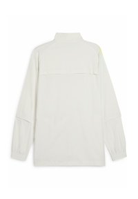T-shirt blanc à manches longues avec un col montant, comportant une poche arrière et des poignets élastiques. Texture lisse et coupe décontractée. Plusieurs détails de couture.