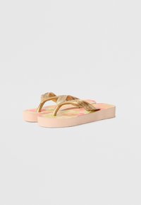 Pink flip-flops with gold straps, featuring a textured design and floral pattern on the footbed. Rubber sole; lightweight construction.