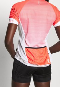 Camiseta deportiva de manga corta, ajustada al cuerpo, en un degradado de naranja a blanco con rayas horizontales, que presenta un bolsillo trasero y detalles en negro.