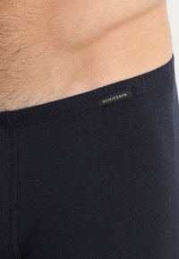Boxer shorts neri in cotone con una cintura morbida, dotati di una piccola etichetta con logo. Texture liscia con un design aderente.