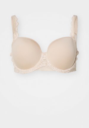 Beige polstret BH med bølget blonder langs stroppene og båndet. Glatte kopper med en teksturert blonderunderbånd. justerbare stropper.