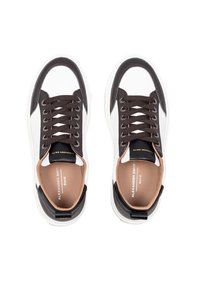 Sneaker in pelle bianca e marrone con punta rotonda, suola spessa bianca, lacci marroni scuri e interno beige; logo sulla linguetta.