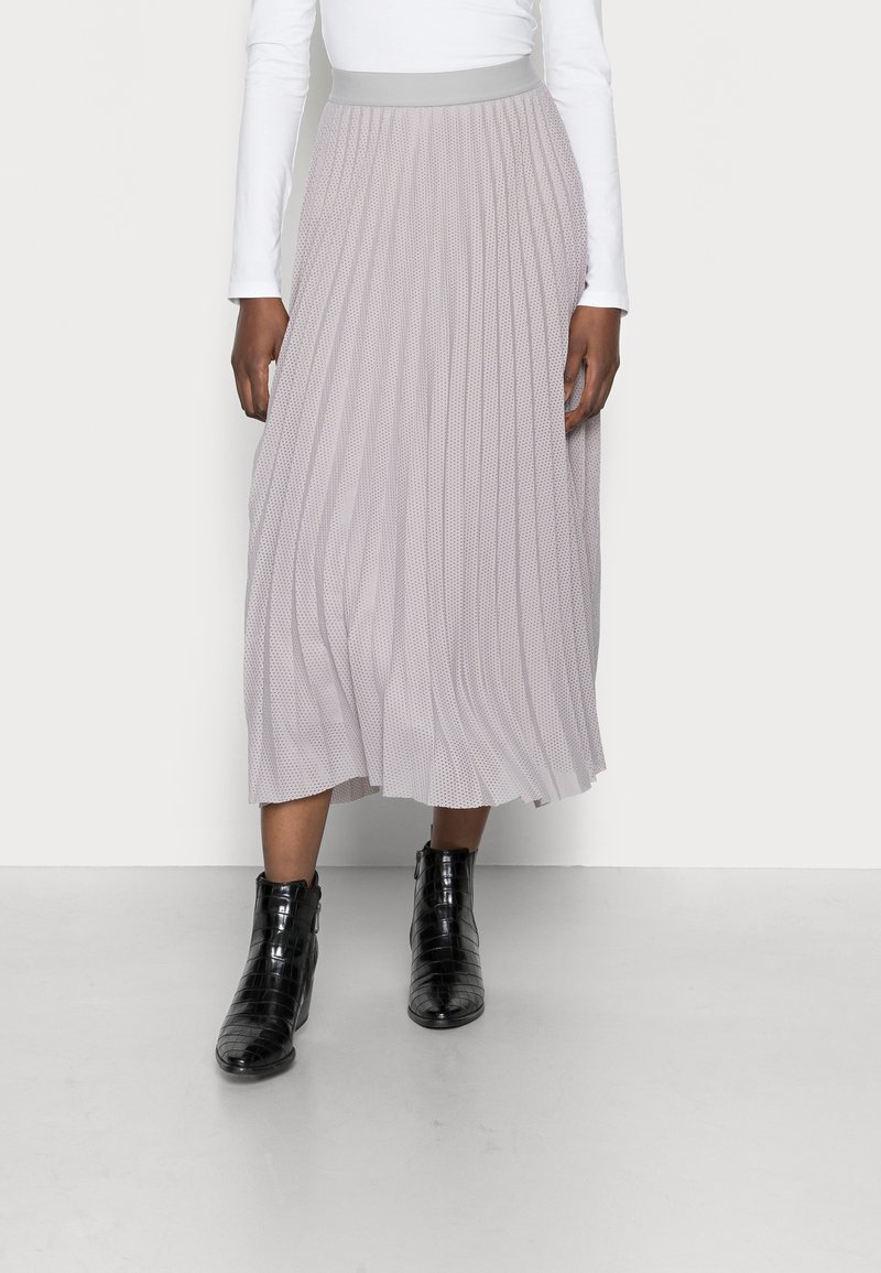 Plissé midi-rok in lichtgrijs met een soepele tailleband. Geharmonieerd met glanzende zwarte enkellaarzen met een gestructureerde afwerking.