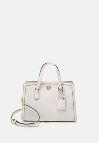 Biała skórzana torebka z podwójnymi uchwytami u góry, odczepianym paskiem na ramię, złotymi akcentami oraz małym dodatkiem w postaci zawieszki. Prostokątny kształt.