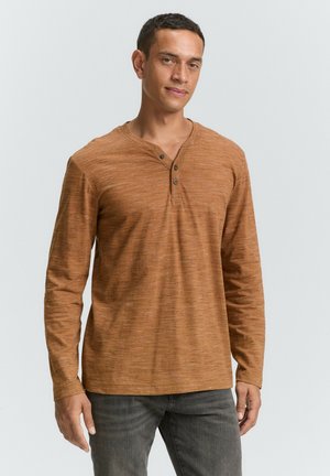 Langærmet, rustfarvet henley-shirt lavet af tekstureret stof, med en V-hals, tre knapper og en afslappet pasform.
