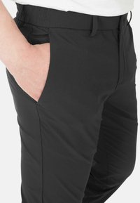 Pantaloni neri con una texture liscia, design slim fit, dotati di tasche laterali e fascetta in vita elastica per il massimo comfort.