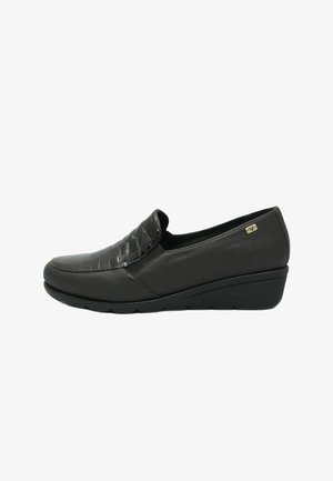 Scarpa nera slip-on con tomaia in pelle tessuta e strutturata e tacco curvo e liscio. Presenta un leggero plateau e un marchio discreto sul lato.