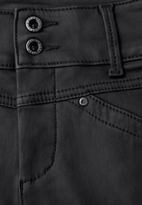 Pantalones negros con una textura suave. Presentan dos botones plateados en la cinturilla y un remache metálico en un bolsillo frontal. Detalle de costura visible.