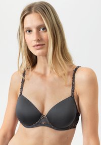 Grijze gevoerde beha met bloemenkantaccenten op de verstelbare bandjes en een decoratieve strik in het midden, gladde stof, gestructureerde vorm.