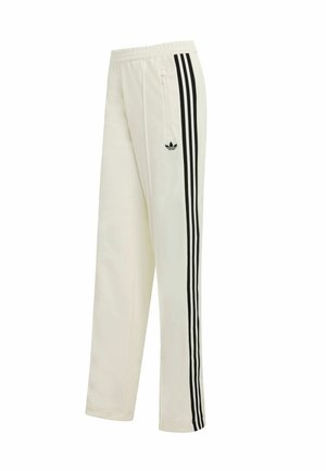 Pantalones de chándal color crema con diseño de triple raya negra a lo largo de los lados, con un pequeño logo y una cintura elástica.